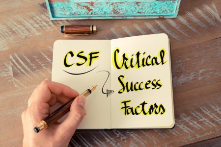Retro effect and toned image of a woman hand writing a note with a fountain pen on a notebook. Business Acronym CSF as Critical Success Factors as business concept image